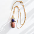 Load image into Gallery viewer, Handmade brass pendant necklace with rhodonite and lapis lazuli stones on 18k gold satellite chain, full flat lay, artisan jewelry by bykjones NC