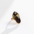 Load image into Gallery viewer, : Close-up macro of natural black lip shell cabochon in hand-metalsmiths brass ring showing iridescent surface, one-of-a-kind artisan jewelry by bykjones