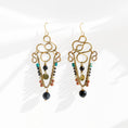 Load image into Gallery viewer, Brass chandelier earrings with sculptural wire work, onyx, turquoise, white howlite, and jasper stones — handmade by bykjones