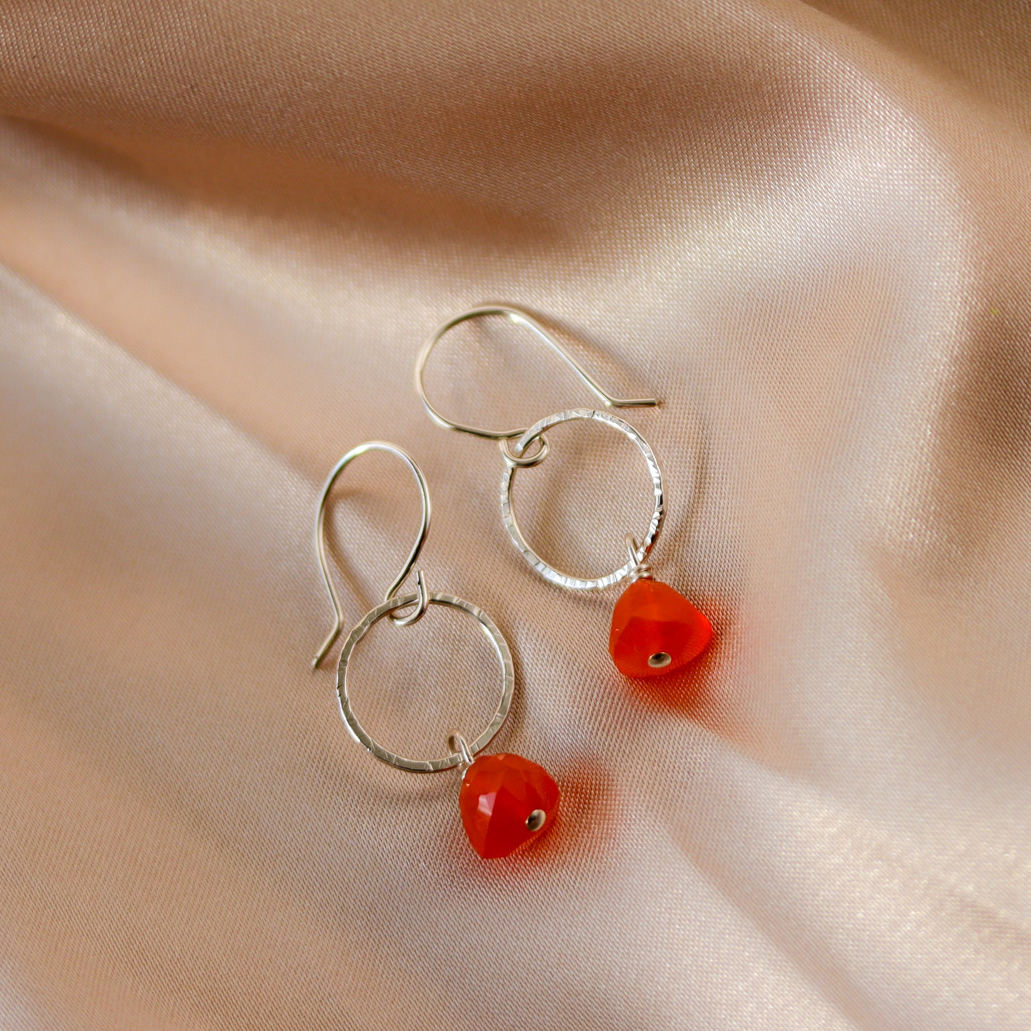 Handmade sterling silver earrings featuring bright orange carnelian gemstones in a minimalist drop dangle style.