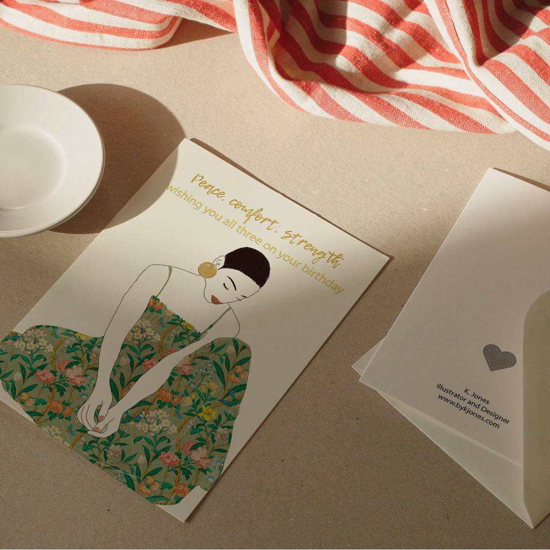 Serene birthday card illustration of a woman in a flower dress with gold foil earrings.