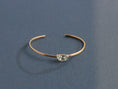 Load image into Gallery viewer, Side view of delicate hand-forged brass cuff bracelet showing thin wire profile and prong-set Swarovski crystal, artisan jewelry by bykjones
