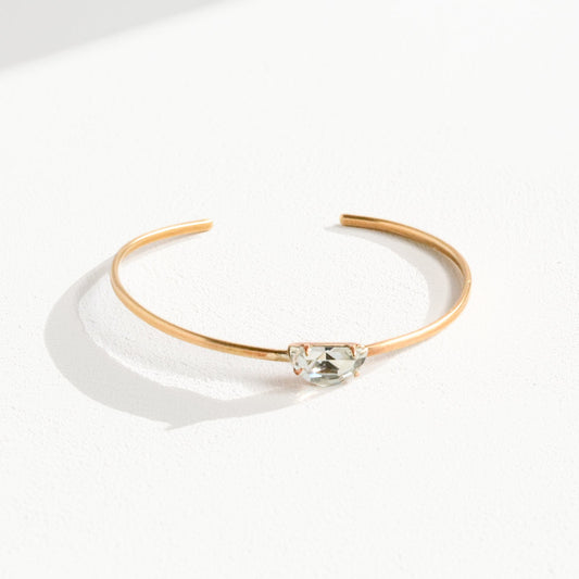 Handmade brass cuff bracelet with centered Swarovski clear crystal, photographed flat lay on white linen background, made by bykjones NC jewelry artist bykjones.jpg