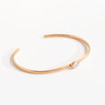 Load image into Gallery viewer, Handmade brass cuff bracelet with bezel-set opalite stone cabochon on warm linen background, dainty minimalist jewelry by bykjones NC
