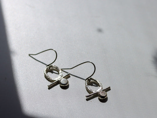 Close-up of hand-forged silver earrings with organic design