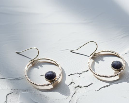 Handmade sterling silver earrings with sodalite gemstone on textured white background