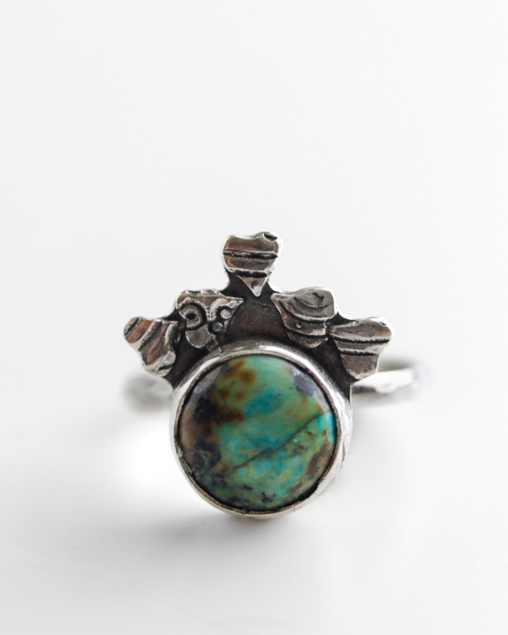 Boho-minimalist silver ring adorned with heart motifs and blue-green African Turquoise, handcrafted statement piece.