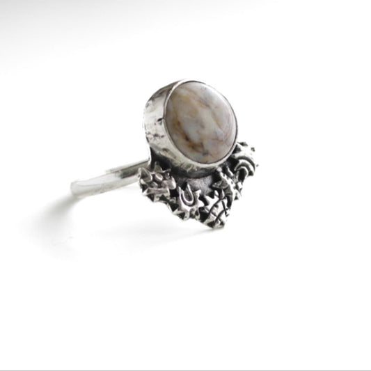 Boho-minimalist sterling silver statement ring featuring swirled Brazilian agate center and decorative starburst details, handcrafted.